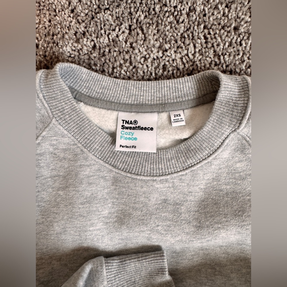 TNA Women’s Cozy Fleece Crewneck Sweater - Light Gray. Cropped.